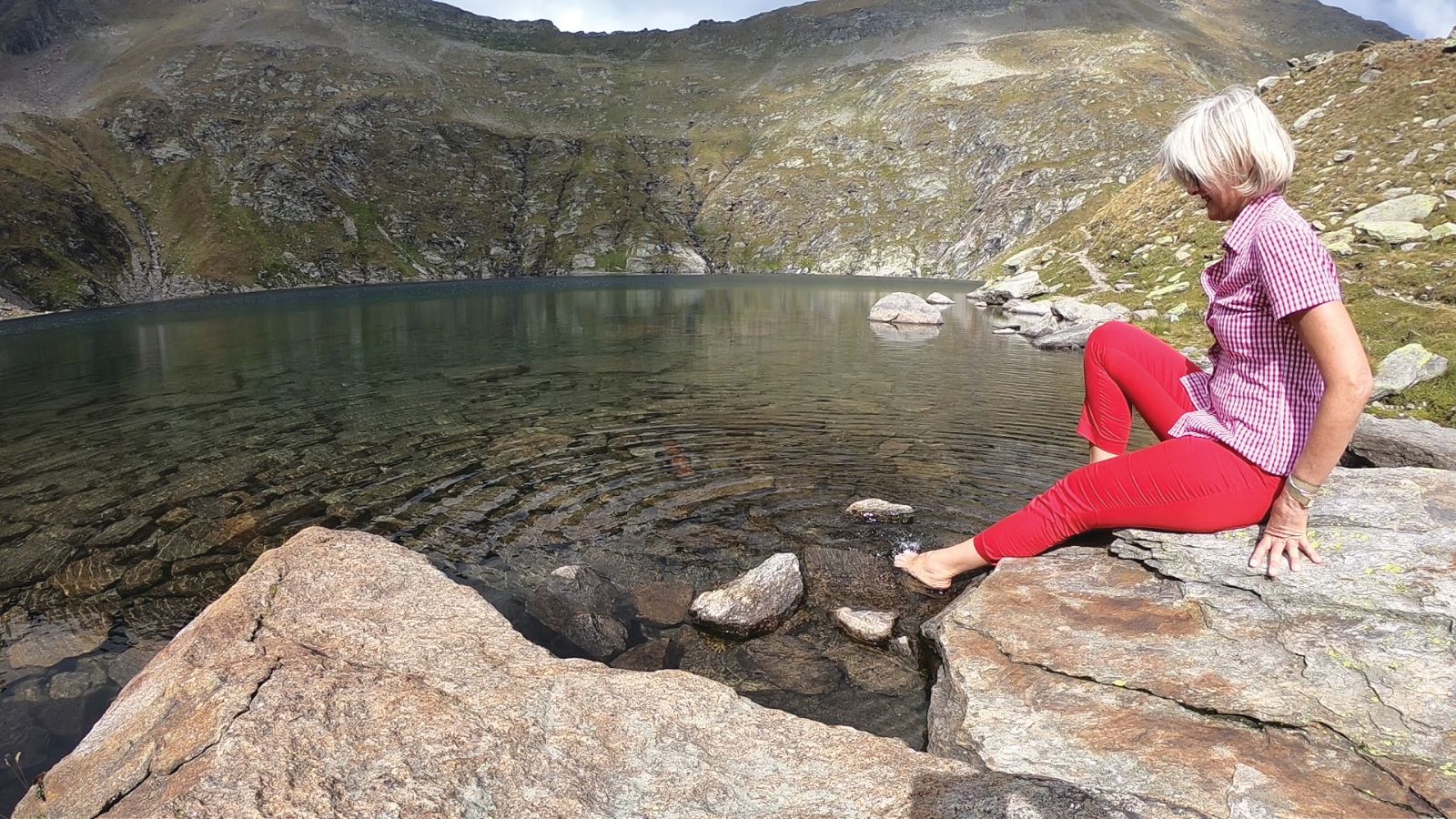 Provare l’acqua gelida di un laghetto alpino